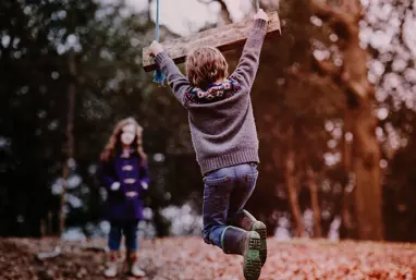 Two children playing in forest