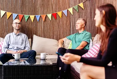 Three people sitting on sofas