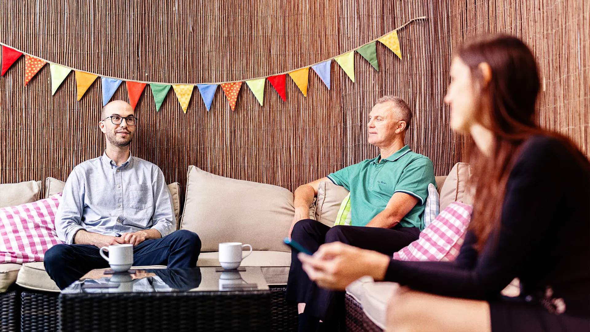 Three people sitting on sofas