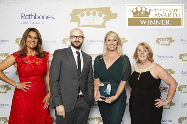 Four people standing with awards